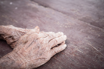 Hands Asian elderly woman grasps her hand on lap, pair of elderly wrinkled hands and Traces of hard work, World Kindness older and Adult care concept. Senior citizen is common euphemism for an old