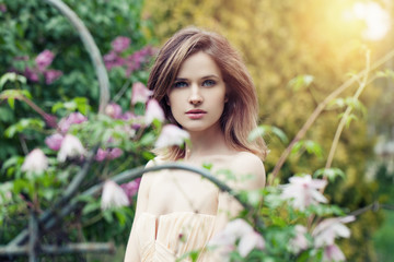 Naklejka premium Young pretty woman in spring garden background
