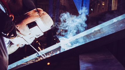 Industrial worker is welding the metal creates smoke and fire splash, hardwork and dangerous works,...