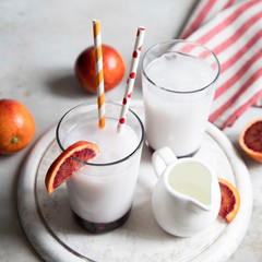 Two glasses of Italian soda with blood orange syrup, milk and ice.