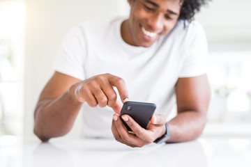 Close up of african american man hands using smartphone and smiling