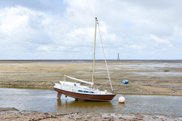 Sailing boat beached on the sand with horizon in the background