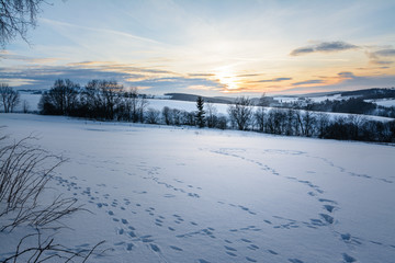 Fußspuren im Schnee beim Abendrot