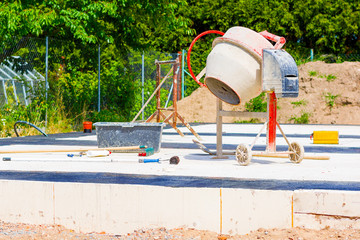 Construction of a house and concrete mixer on the foundations of the house