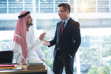 Arabian businessman discussing with Asian businessman in office with smile face, business concept