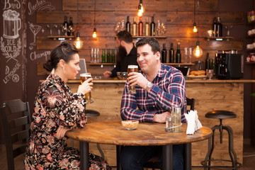 Attractive couple drinking beer in a beautiful hipster pub.
