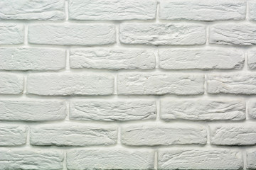 Wall is made from bricks and painted with white color.
