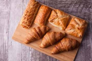An assortment of freshly baked pastry aligned on cutting board