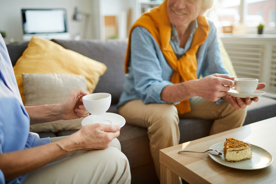 Mid section portrait of unrecognizable mature couple enjoying tea during weekend at home, copy space