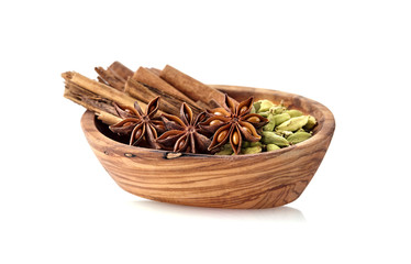 Cardamon, cinnamon, anise in wooden bowl on white background. Spices isolated.