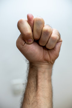 Hand doing a fig sign over white background