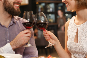 Love to see you smile. Cropped shot of a happy smiling couple cheering with glasses full of wine at their date night at the restaurant