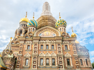 Fototapeta na wymiar Under construction of the Church of the Savior on Spilled Blood, under cloudy blue sky in summer of Saint Petersburg, Russia
