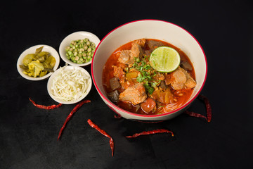 Nam Nguan Noodle ( Rice noodles with spicy pork sauce) on black table