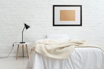 modern bedroom with bed and black frame on white brick wall