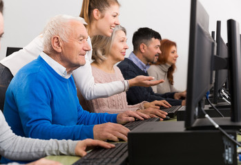 Young female tutor explaining how to use computers