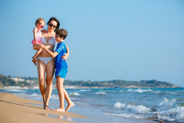 Young mother with her two kids on tropical beach vacation