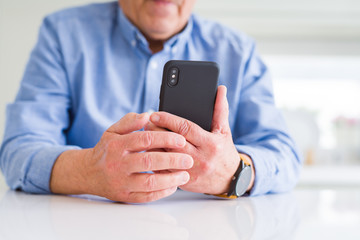Close up of man hands using smartphone over white table