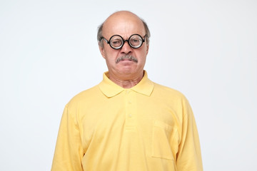 Obraz premium senior hispanic man looking at camera wearing funny glasses