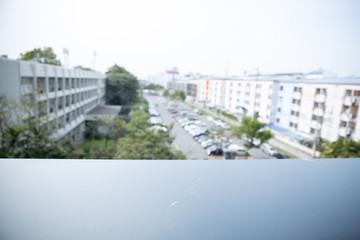 blurred of car in outdoor parking area with black balcony for display or design product.