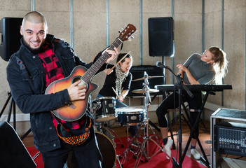 Bearded guy soloist playing guitar in studio