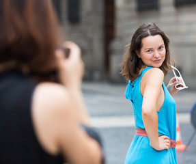 Girl posing to photographer on city walk