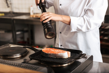 Smiling woman chef cook wearing uniform cooking
