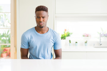 Handsome african american man wearing casual t-shirt at home depressed and worry for distress, crying angry and afraid. Sad expression.