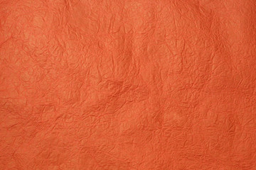 Paper texture for background in the trendy coral color. Structure of wrinkled crepe coral paper.