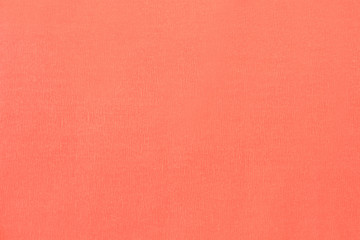 Fototapeta premium Textural of Coral background of wavy corrugated paper, closeup. Structure of wrinkled crepe light coral cardboard