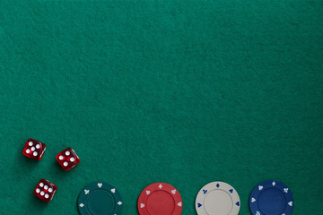 Concept of gambling in casino, sports poker. Gaming dice and colored gaming chips on green gaming table.