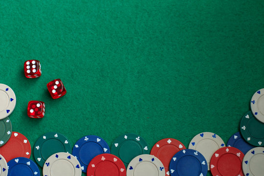 Concept of gambling in casino, sports poker. Gaming dice and colored gaming chips on green gaming table.