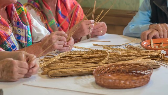 There are beautiful wheat plaits on the table. Ladies continue making them. This is a fun past time. They are also singing at the same time.