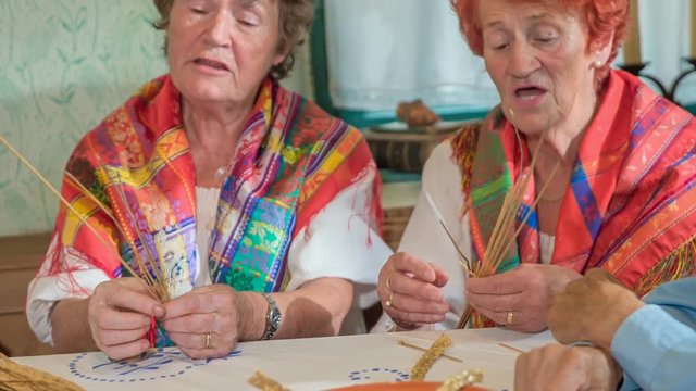 These ladies are singing and doing some old-fashioned chore together at the same time.