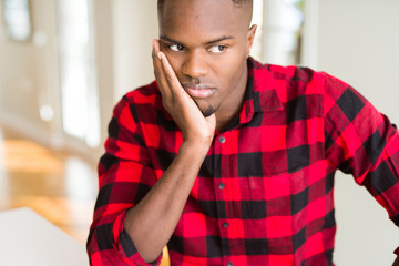 Handsome african american man thinking looking tired and bored with depression problems with crossed arms.