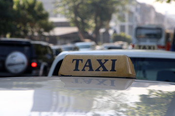 Taxi light sign or cab sign in brown color with black text on the car roof.
