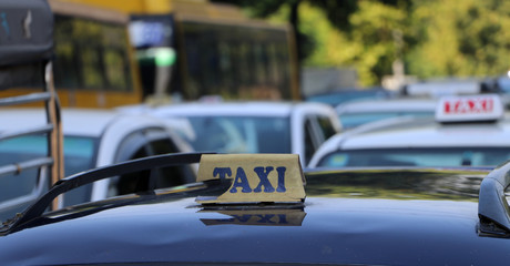 Broken taxi light sign or cab sign in drab yellow color with blue text on the car roof.