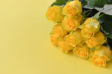 A bouquet of fresh yellow roses flowers with leaves on an isolated background. Flat lay, close-up. corner composition. postcard birthday floral arrangement