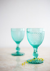 Blue Vintage Goblets and yellow mimosa flowers . Wineglasses on whight background.