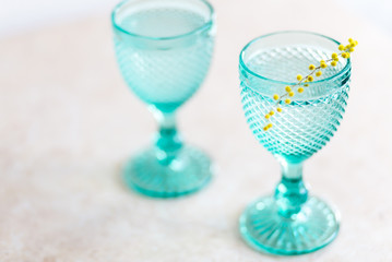 Blue Vintage Goblets and yellow mimosa flowers . Wineglasses on whight background.