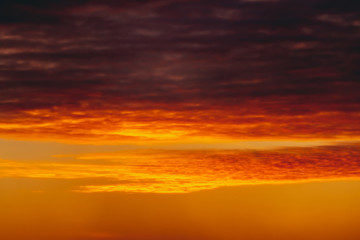 Fiery red blood vampire dawn. Amazing warm dramatic fire cloudy sky. Vivid orange sunlight. Atmospheric background of sunrise in overcast weather. Hard cloudiness. Storm clouds warning. Copy space.
