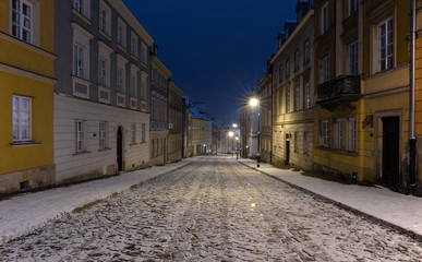 The snow-covered street of the old city in Warsaw during the winter night
