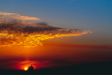 Sunny shine on clouds. Wonderful vivid dawn. Beautiful calm orange sunset. Scenic surreal sunrise. Amazing red blue cloudy sky. Picturesque sundown. Atmospheric cloudscape. Circle of sun above horizon