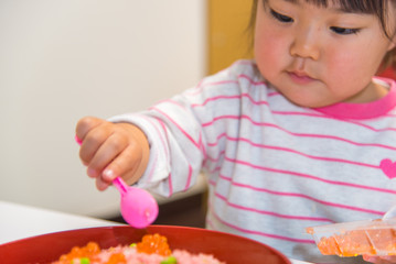 Obraz na płótnie Canvas ちらし寿司を準備する子供