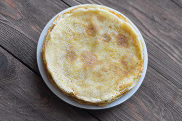 Maslenitsa, hot freshly baked Russian pancakes on wooden background