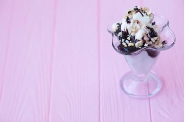 Vanilla sundae ice cream in cup on pink background. Ice cream in a glass bowl.