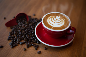 Tulip latte art with coffee beans on wooden table