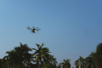agriculture drone flying & spraying liquid fertilizer or herbicide in farm