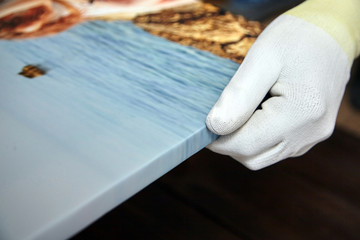 Gallery wrap, photo printed on glossy synthetic canvas and stretched on wooden stretcher bar, lateral side closeup. Selective focus