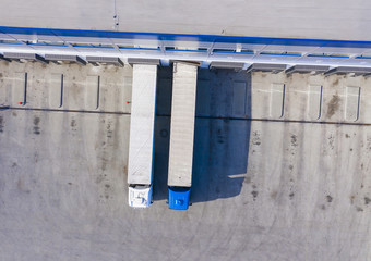 Logistics center. Trucks in warehouse distribution center. Aerial View